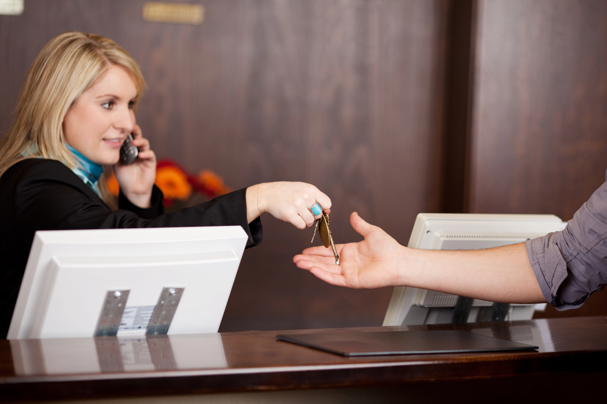 Receptionist handing keys to a guest